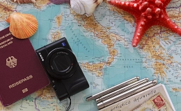 Reisepass mit Weltkarte und Kamera (dekoratives Bild)