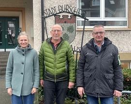 Klimaschutzmanagerin Anne Sprinz mit den Wärmepumpenbotschaftern Herrn Eling und Herrn Adler vor dem Nebeneingang des Burscheider Rathauses.